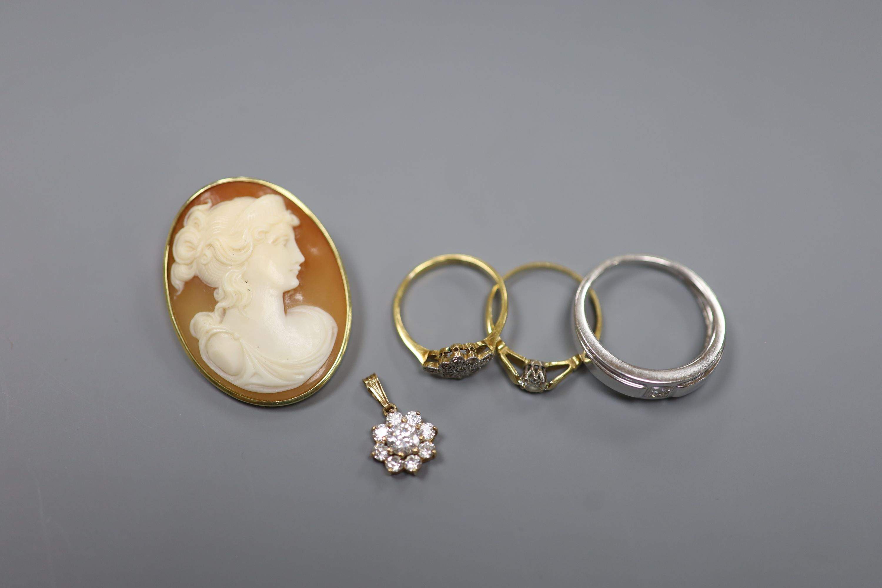 A modern 9ct white gold and diamond ring and a 9ct pendant, gross 4.7 grams, two 18ct and diamond rings, gross 3.6 grams and a yellow metal mounted cameo shell brooch, gross 9.5 grams.